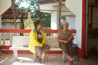 Full length of woman sitting outdoors