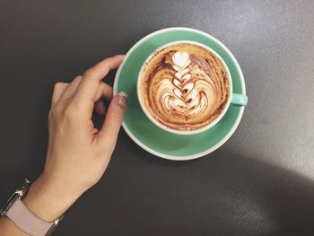 High angle view of cropped hand holding coffee cup