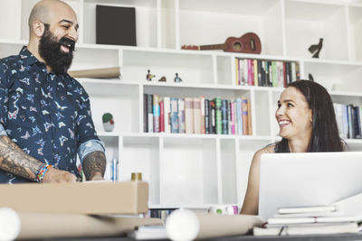 Happy male and female architects talking at home office