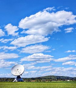 Scenic view of a satellite antenna on field against sky