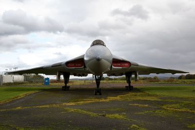 Airplane on runway against sky