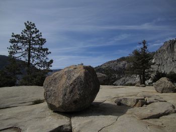 Rocks by trees against sky