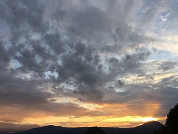 Low angle view of silhouette mountains against dramatic sky