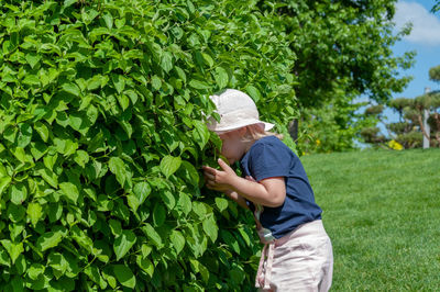 Side view of a boy standing by plants