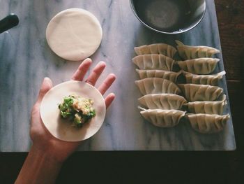 Cropped image of man preparing dumplings at home