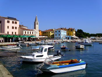 Boats moored at dock against clear blue sky