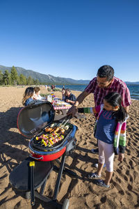 A family enjoys a beach bbq on the shoreline of lake tahoe, nv