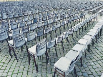 Empty chairs arranged on cobbled footpath