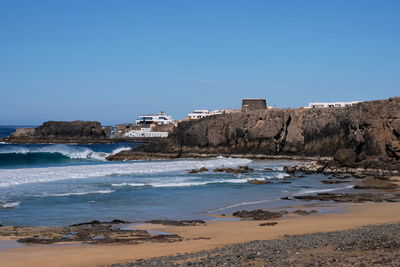 Scenic view of beach against clear blue sky