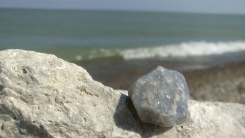 Close-up of pebbles on beach against sky