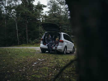 Mother and toddler sitting in open car