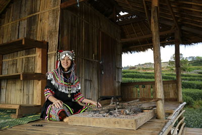 Woman sitting on wooden structure