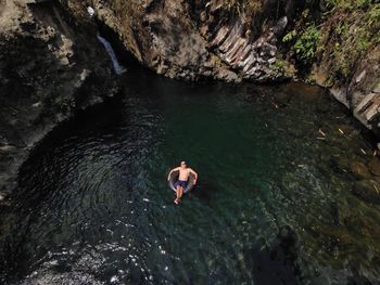 High angle view of man swining in the waterfall