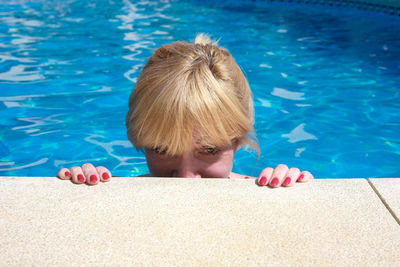 Portrait of smiling woman in swimming pool on sunny day