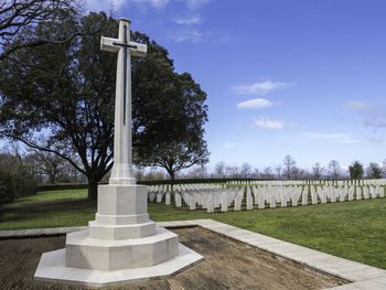 Trees in cemetery against sky