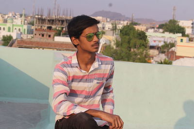 Mature man sitting by building