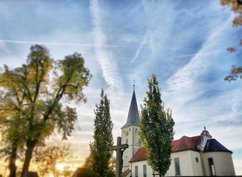 Low angle view of trees and building against sky