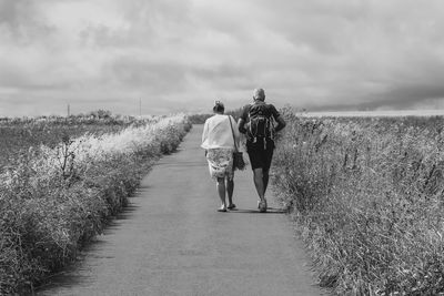 Rear view of women walking on footpath