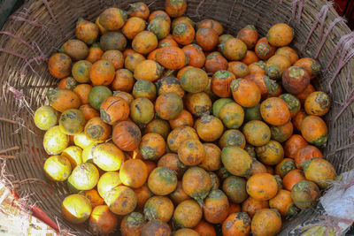 High angle view of oranges in basket for sale at market stall