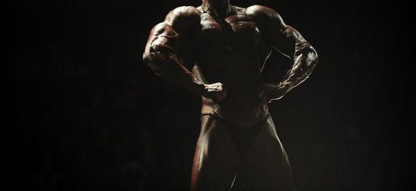 Midsection of body builder posing during competition