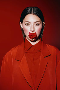 Portrait of woman wearing mask against yellow background