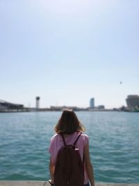 Rear view of woman looking at sea against sky