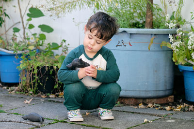 Boy playing with a stick in the garden