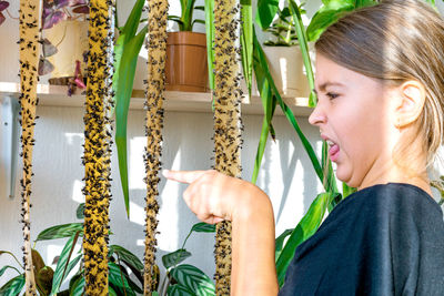 Portrait of young woman holding plants