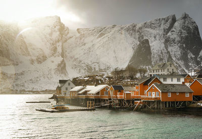 Houses by sea against sky