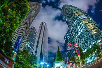 Low angle view of modern buildings against cloudy sky