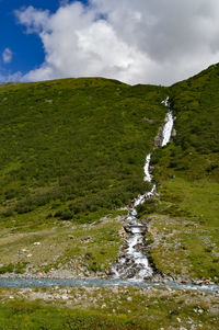 Scenic view of waterfall against sky