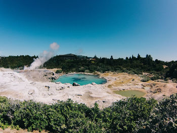 Scenic view of lake with hot springs against clear sky