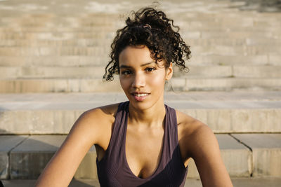 Mid adult sportswoman on staircase during sunny day