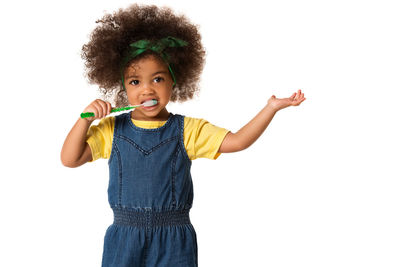 Portrait of smiling girl standing against white background