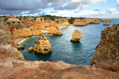 Rock formations by sea against sky