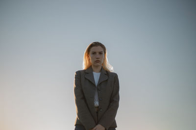 Portrait of a young woman against clear sky during sunset