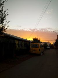 Cars on road against sky during sunset