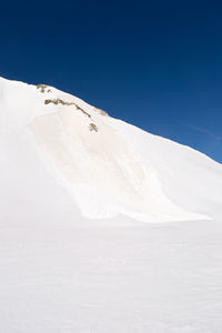 Scenic view of snowcapped mountains against clear blue sky