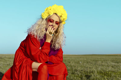 Portrait of woman wearing red hat against plants