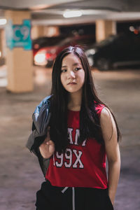 Beautiful young woman standing in parking lot