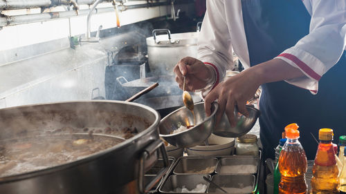 Chef stir fry in wok. professional cooking in kitchen