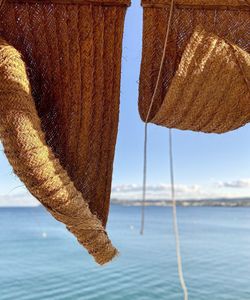 Close-up of basket on beach against sky