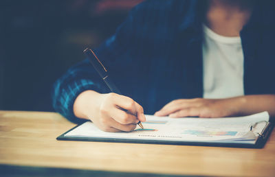 Close-up of man holding hands on table