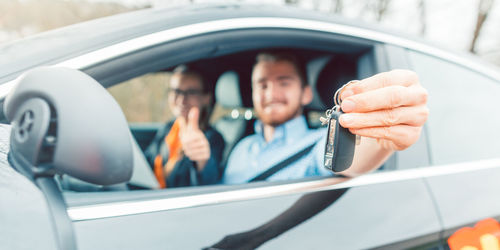 Portrait of man holding camera in car