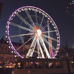 Low angle view of illuminated ferris wheel at night