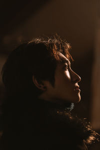 Profile view of young man sitting in darkroom