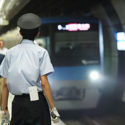 Low angle view of man standing in front of railroad station platform