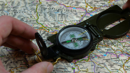 Cropped hand holding navigational compass