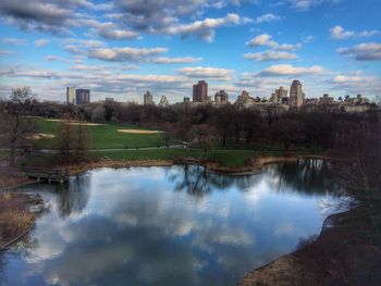 Scenic view of river by buildings against sky