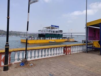 Boats moored at harbor by sea against sky